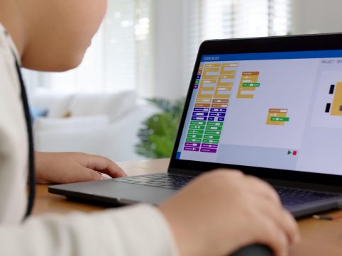 Young student coding robot car